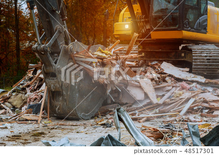 old house being demolished by a large backhoe old house being demolished by a large backhoe 48517301