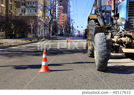 Orange traffic cones enclose repair area street 48517633