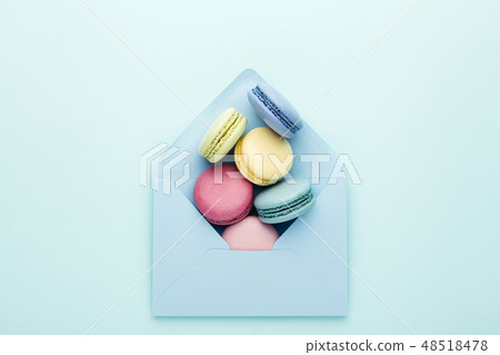 Colorful macarons in envelope on turquoise background. 48518478