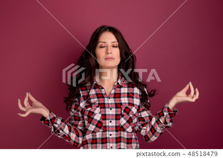 Pretty woman in a keep calm pose isolated over the dark pink background. Pretty woman in a keep calm pose isolated over the dark pink background. 48518479