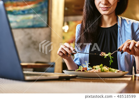 Snack time heals all wounds. Businesswoman having lunch in company's restaurant. Cozy interior Snack time heals all wounds. Businesswoman having lunch in company's restaurant. Cozy interior 48518599