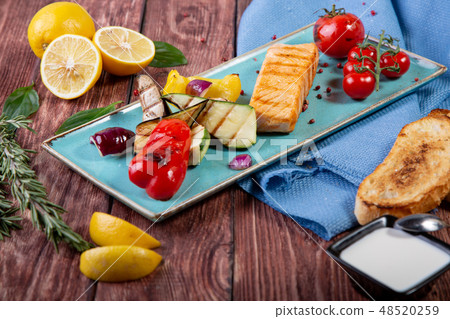 Grilled salmon served with grilled vegetables - top view Grilled salmon served with grilled vegetables - top view 48520259