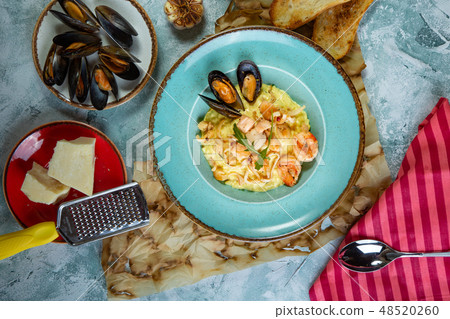 photo of delicious risotto with saffron and seafood on table. photo of delicious risotto with saffron and seafood on table. 48520260