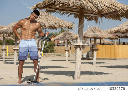 Sexy shirtless fitness model posing on the beach at the seaside. 48520576