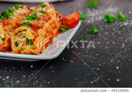 Cannelloni with spinach and ricotta baked in sauce Cannelloni with spinach and ricotta baked in sauce 48520685