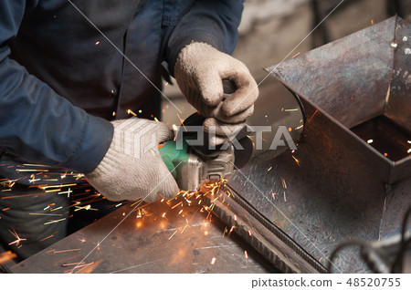 Blacksmith grindering metal parts shot from above Blacksmith grindering metal parts shot from above 48520755