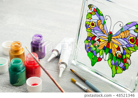 Artisan painting with stained glass paints. 48521346