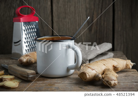 Healthy ginger tea cup, ginger root and grater. 48521394