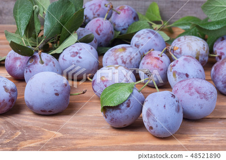 plums with leaves on the wooden background 48521890