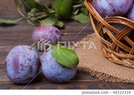 plum in a wicker basket on the wooden background with sackcloth plum in a wicker basket on the wooden background with sackcloth 48522339