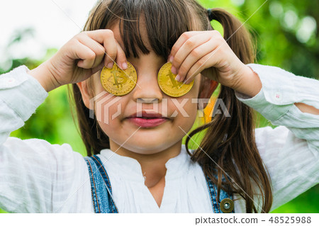 Little girl kid holding bitcoin digital money. Little girl kid holding bitcoin digital money. 48525988
