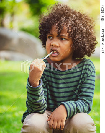 African american child eating snack stick. African american child eating snack stick. 48526022