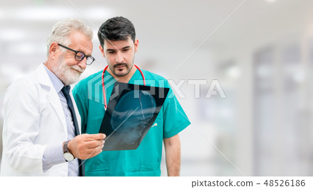 Doctors at hospital working with another doctor. 48526186