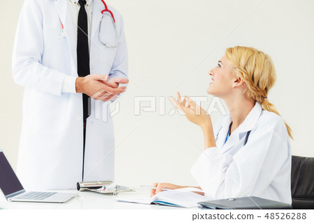 Female doctor at hospital talking to her partner. 48526288