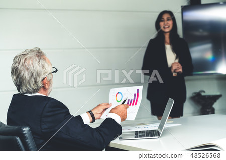 Businesswoman presents senior executive manager. Businesswoman presents senior executive manager. 48526568