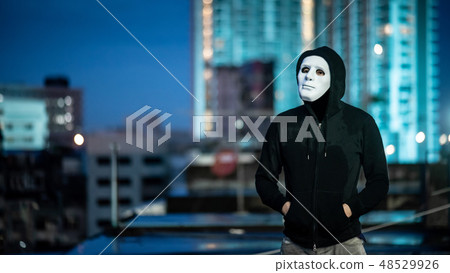 Mystery man in white mask standing on rooftop 48529926
