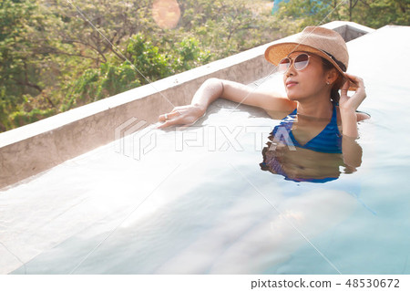 Happy asian woman enjoy swimming in the pool. Happy asian woman enjoy swimming in the pool. 48530672