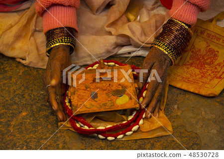 Woman with bangles, deity, saffron colored powder Woman with bangles, deity, saffron colored powder 48530728