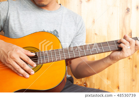 Close up asian man playing guitar 48530739