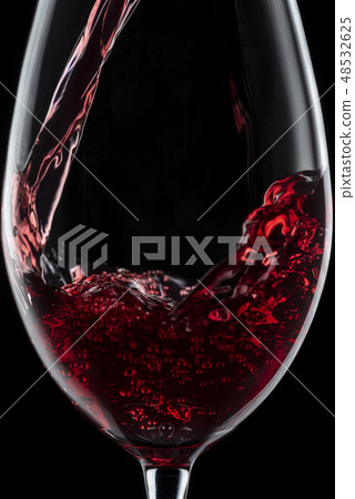 將酒倒入玻璃杯中 將酒倒入玻璃杯中 48532625