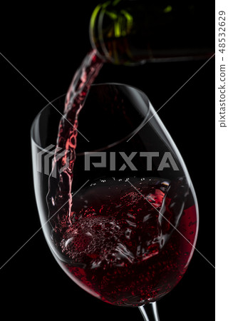 將酒倒入玻璃杯中 將酒倒入玻璃杯中 48532629