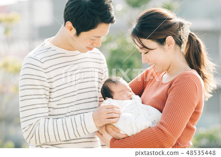 A young couple holding a baby Child-raising generation Newborn 48535448