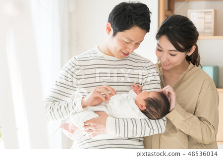 Papa holding a baby and close cuddling Mother raising child rearing newborn 48536014