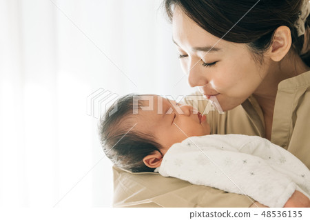 A young mother holding a baby Japanese parent and child newborn 48536135