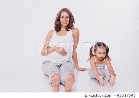 pregnant woman and little girl in tracksuits pregnant woman and little girl in tracksuits 48537548