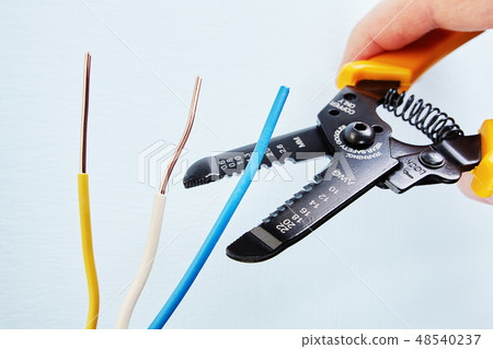 Electrician uses wire stripper cutter during. Electrician uses wire stripper cutter during. 48540237