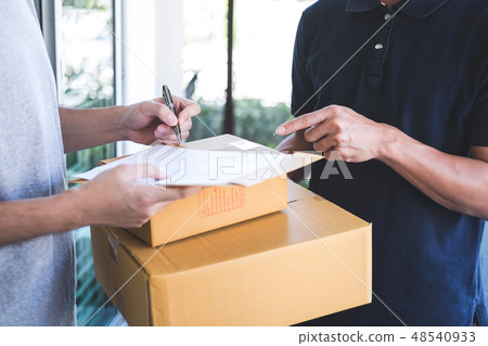 Delivery mail man giving parcel box to recipient, Young man sign Delivery mail man giving parcel box to recipient, Young man sign 48540933
