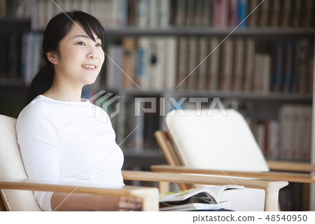 A woman reading in a library 48540950