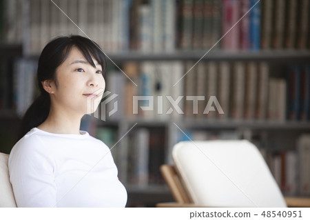 A woman reading in a library 48540951