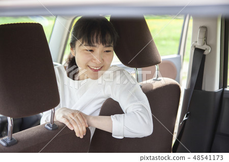 一個女人從駕駛座上轉過身來 48541173