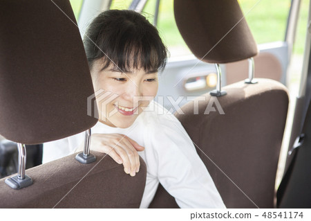 一個女人從駕駛座上轉過身來 一個女人從駕駛座上轉過身來 48541174