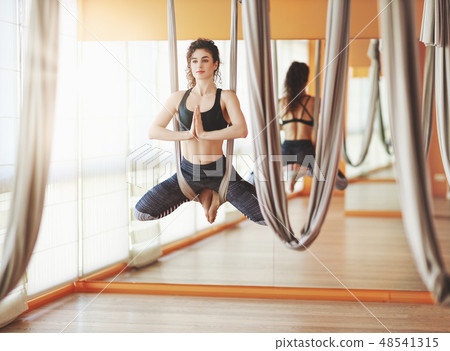 woman doing of Aero yoga of antigravity in hammock 48541315