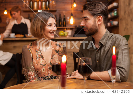 Stylish couple on a romantic date looking deeply into each others eyes Stylish couple on a romantic date looking deeply into each others eyes 48542105
