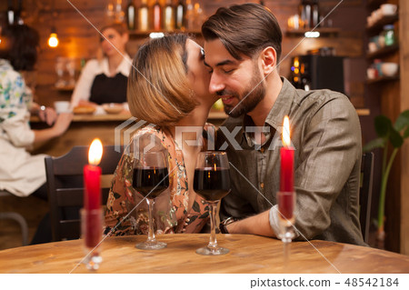 Beautiful woman whispers to her handsome boyfriend ear how much she loves him 48542184