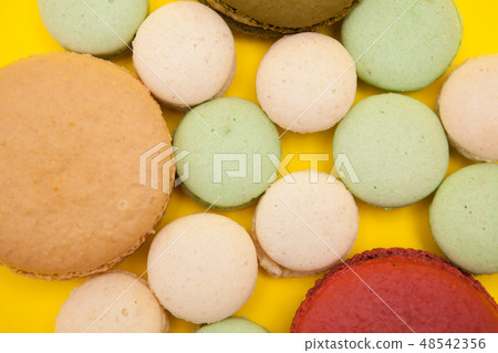 Colorful macaroons cookies cake on yellow background Colorful macaroons cookies cake on yellow background 48542356
