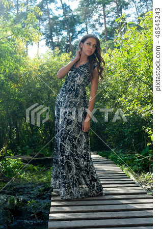 Pretty girl stands on pedestrian bridge Pretty girl stands on pedestrian bridge 48545243