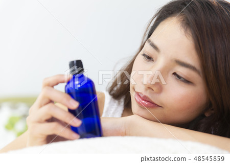 A woman holding a light shielding bottle 48545859