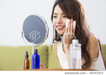 A woman putting lotion A woman putting lotion 48545971