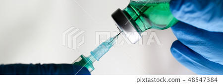 Physician injector arms in sterile uniform holding syringe Physician injector arms in sterile uniform holding syringe 48547384