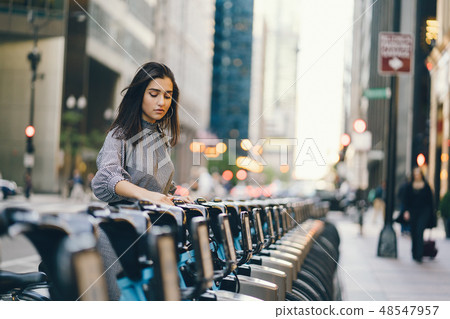 girl renting a city bike from a bike stand 48547957