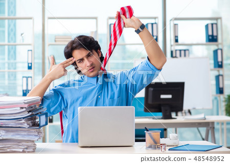 Handsome businessman unhappy with excessive work in the office Handsome businessman unhappy with excessive work in the office 48548952