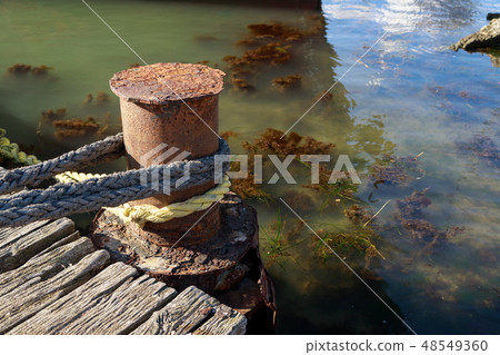 Rope is tied to an old rusty pillar Rope is tied to an old rusty pillar 48549360