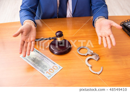 Young handsome judge sitting in courtroom Young handsome judge sitting in courtroom 48549410