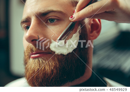 Client during beard shaving in barber shop Client during beard shaving in barber shop 48549929