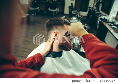 Client during beard shaving in barber shop 48549957