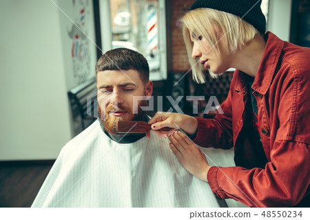 Client during beard shaving in barber shop Client during beard shaving in barber shop 48550234